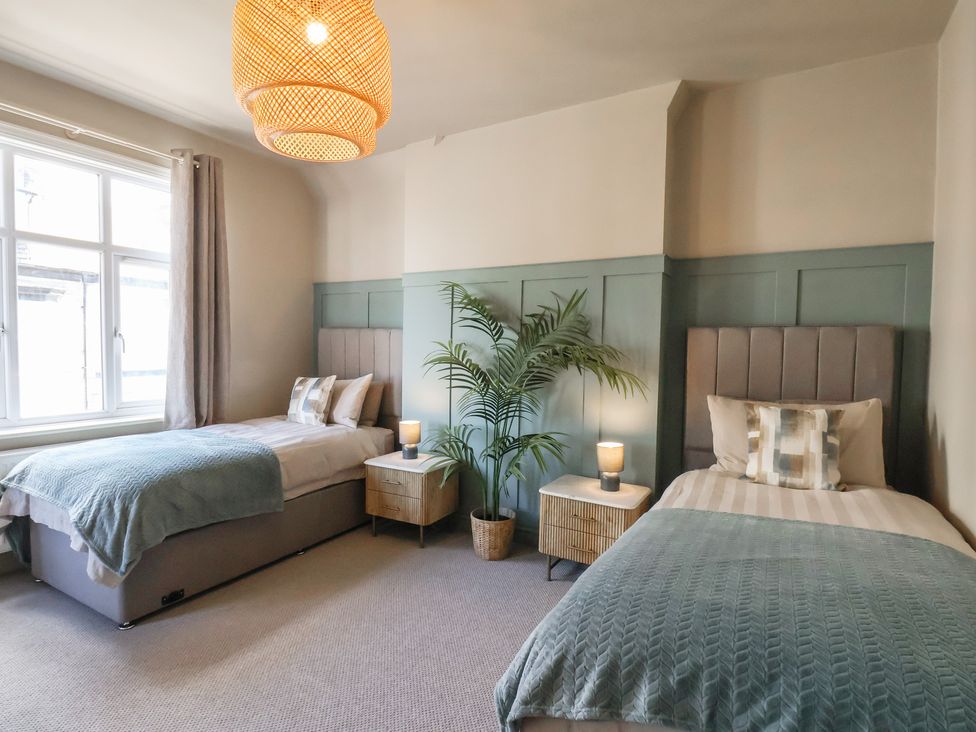 A bedroom with two beds and a plant at Falcon Luxe in Whitby