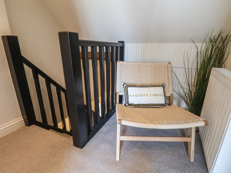 A landing area with a chair and staircase at Falcon Luxe in Whitby
