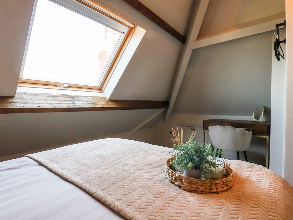 A bedroom with a window, bed, desk, and chair at Falcon Luxe in Whitby