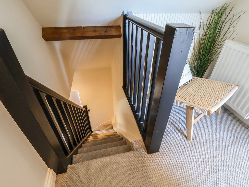 A staircase with a handrail and a chair at Falcon Luxe in Whitby