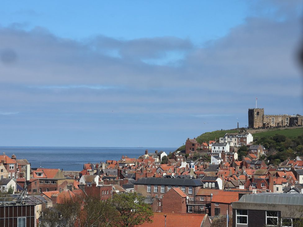A view of houses and the ocean with a castle at Falcon Luxe in Whitby