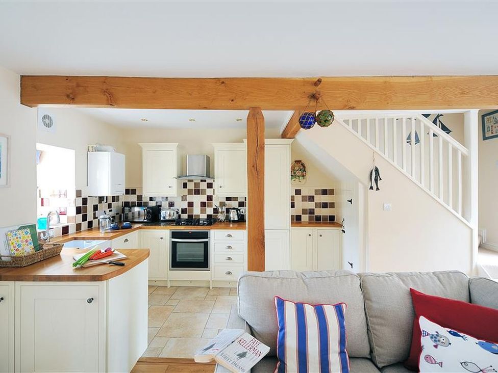 A kitchen with a sofa and staircase at Half Moon Cottage in Lyme Regis