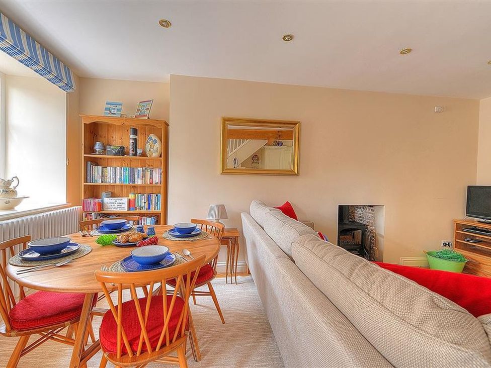 A living room with a dining table set at Half Moon Cottage in Lyme Regis