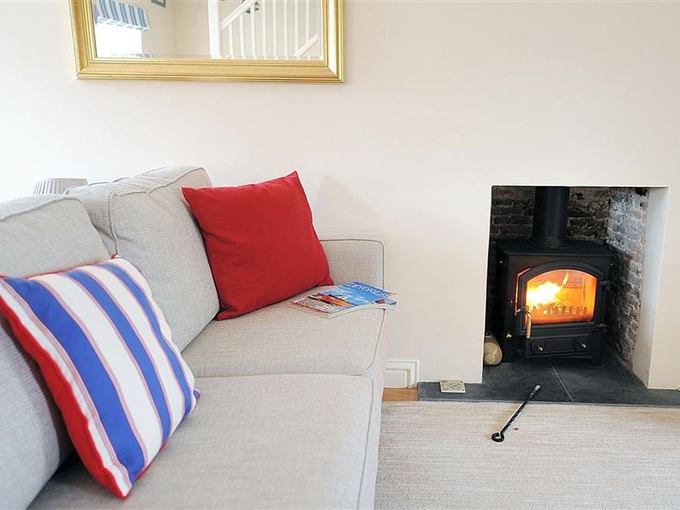 A living room with a sofa and a fireplace at Half Moon Cottage in Lyme Regis
