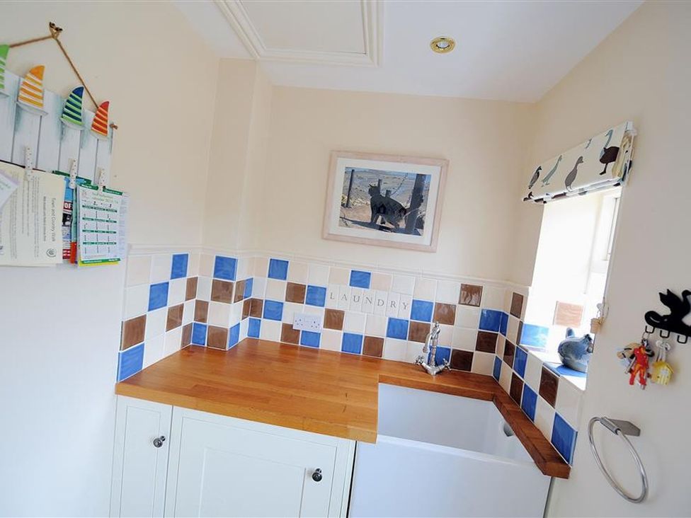 A laundry room with a sink and wooden countertop at Half Moon Cottage in Lyme Regis