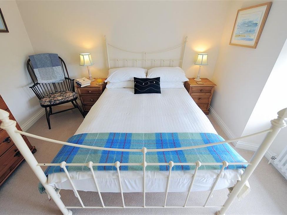 A bedroom with a bed and bedside lamp at Half Moon Cottage in Lyme Regis