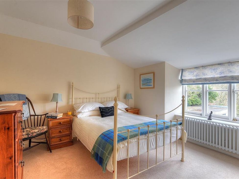 A bedroom with a bed and dresser at Half Moon Cottage in Lyme Regis