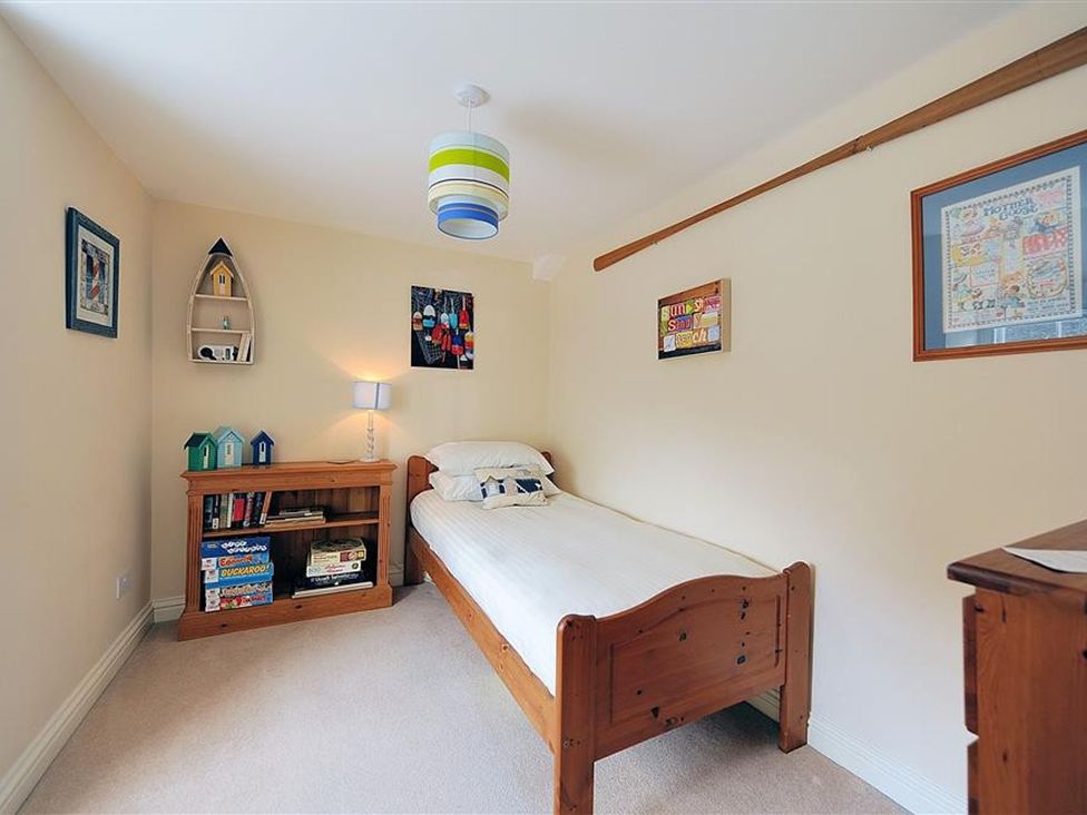 A bedroom with a bed and bookshelf at Half Moon Cottage in Lyme Regis