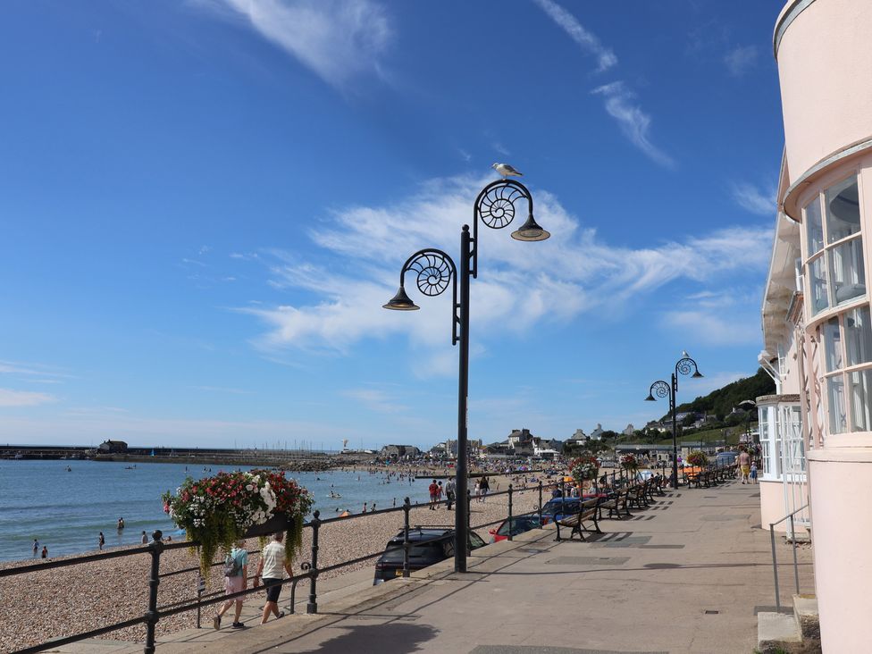 A beach with benches and lampposts at Half Moon Cottage in Lyme Regis