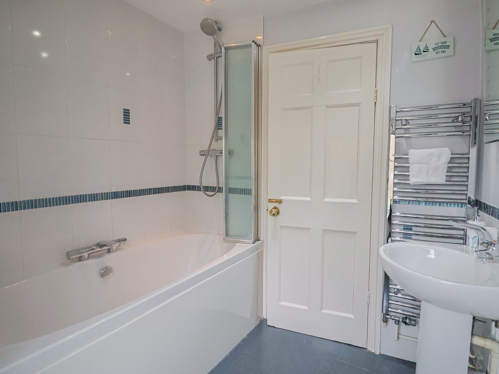 A bathroom with a bathtub and sink at Half Moon Cottage in Lyme Regis