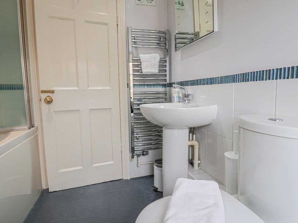 A bathroom with a towel rack and sink at Half Moon Cottage in Lyme Regis