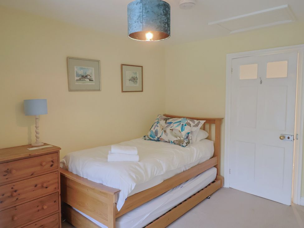 A bedroom with a bed and a lamp at Half Moon Cottage in Lyme Regis