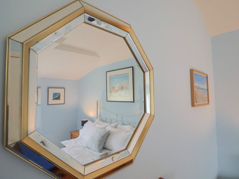 A bedroom with a bed and decorative items at Half Moon Cottage in Lyme Regis