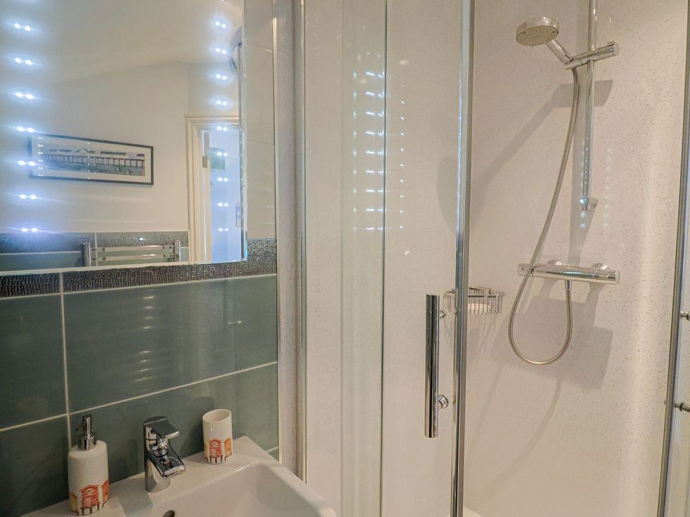 A bathroom with a shower and wash basin at Half Moon Cottage in Lyme Regis