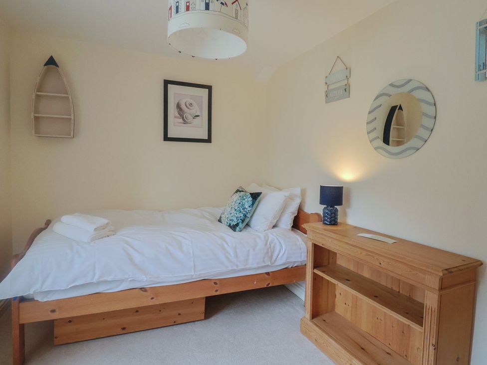 A bedroom with a bed and a cabinet at Half Moon Cottage in Lyme Regis