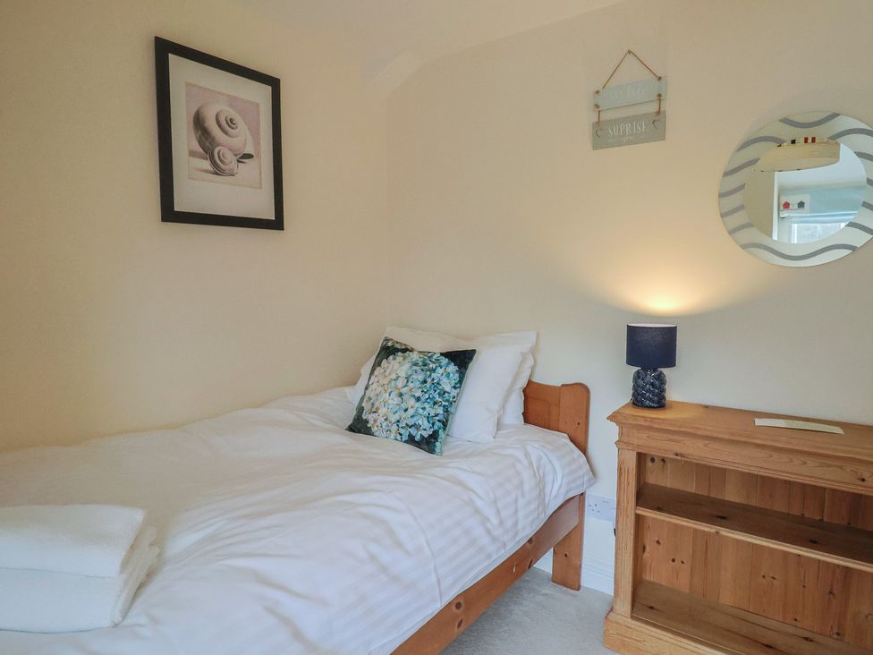 A bedroom with a bed and nightstand at Half Moon Cottage Lyme Regis
