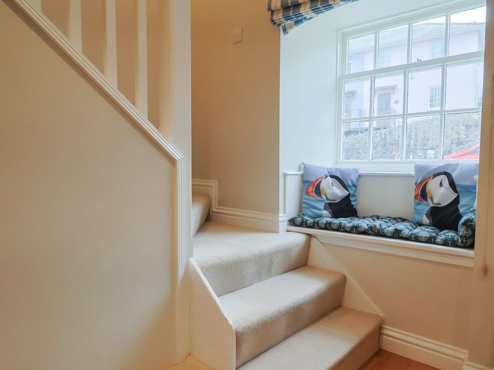 A staircase with a window and cushions at Half Moon Cottage in Lyme Regis