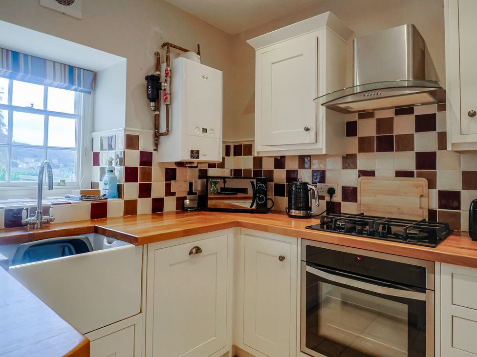 A kitchen with sink, gas stove, and oven at Half Moon Cottage in Lyme Regis