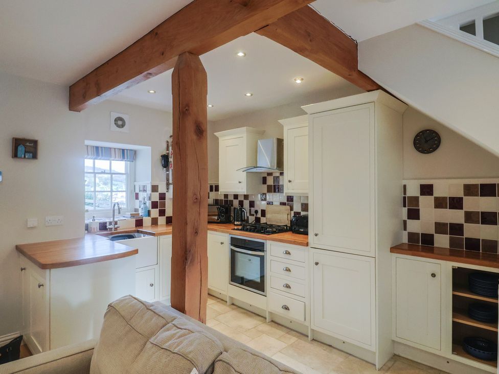 A kitchen with cabinets and appliances at Half Moon Cottage in Lyme Regis