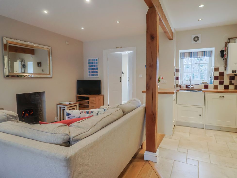 A living room with a sofa and a television at Half Moon Cottage in Lyme Regis
