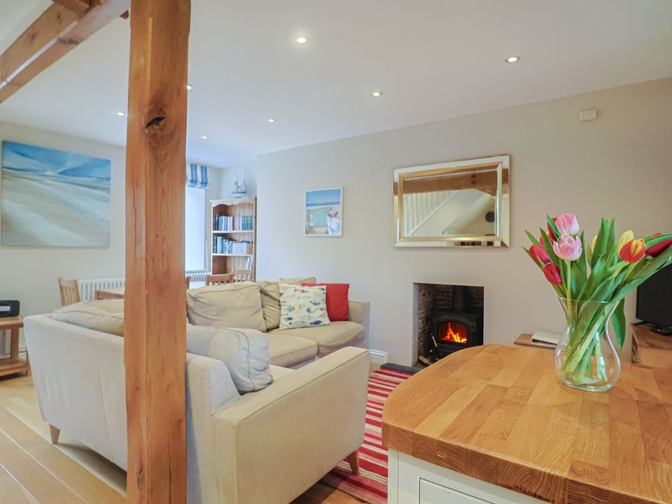 A living room with a sofa and a fireplace at Half Moon Cottage in Lyme Regis