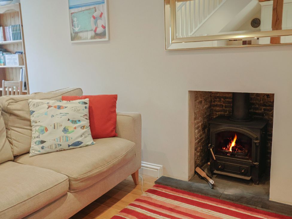 A living room with a sofa and fireplace at Half Moon Cottage in Lyme Regis