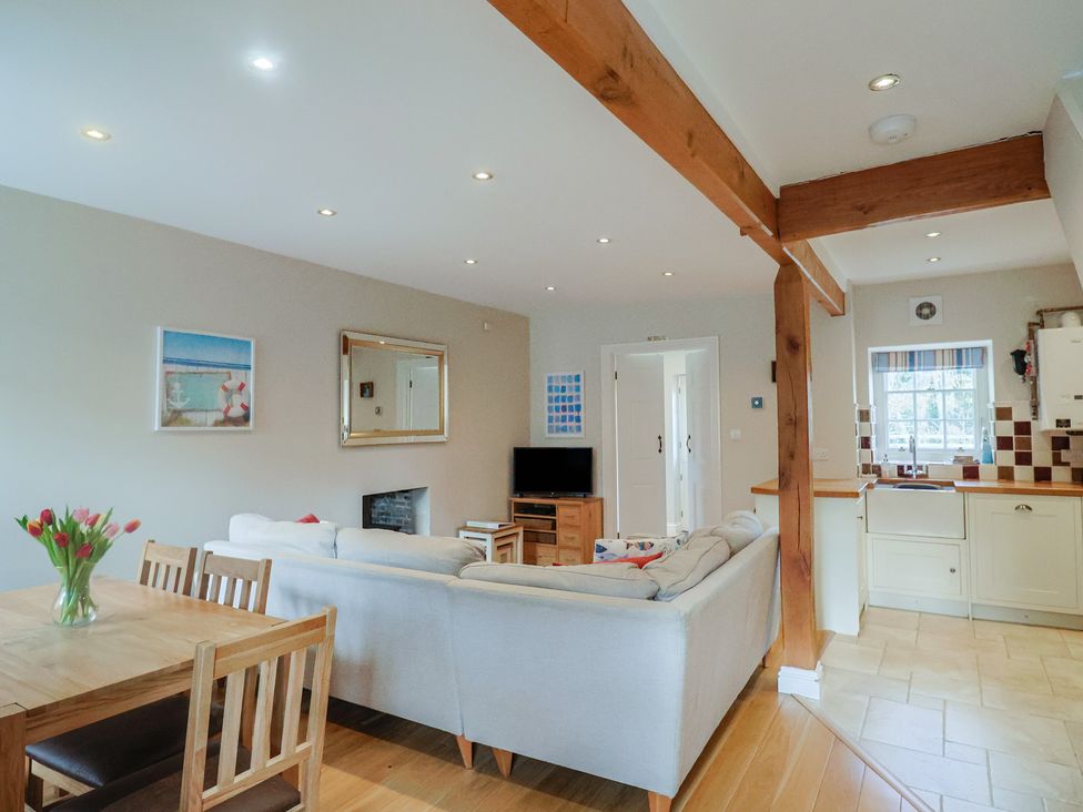 A living room with a sofa and dining table at Half Moon Cottage in Lyme Regis