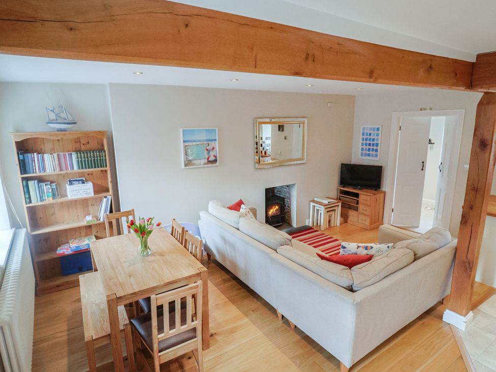 A living room with a sofa and dining table at Half Moon Cottage in Lyme Regis