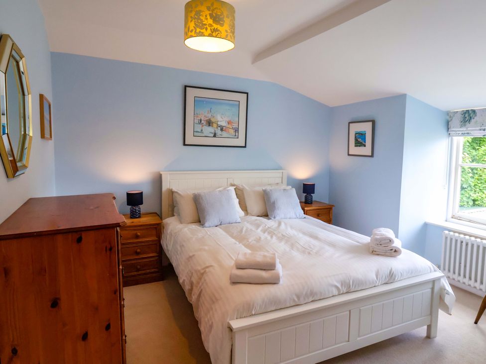 A bedroom with a double bed and dresser at Half Moon Cottage in Lyme Regis