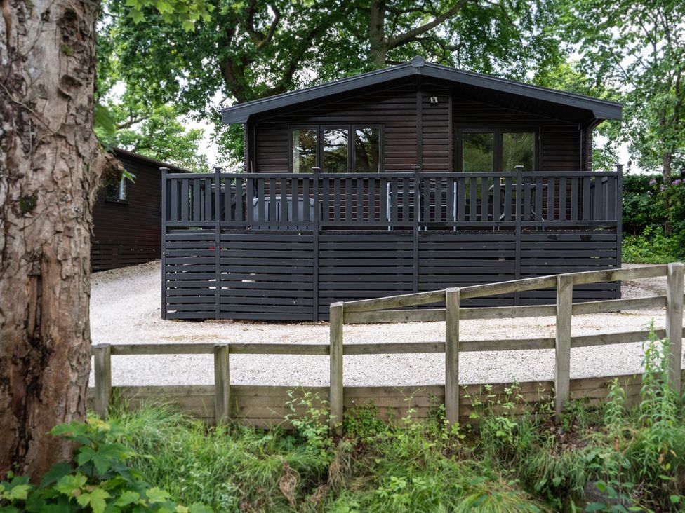 A black wooden house with a deck and fence at Watendlath in Keswick