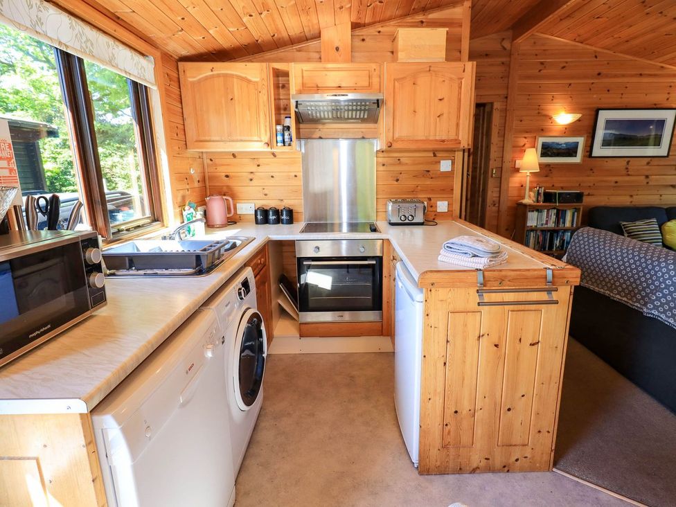 A kitchen with appliances and wooden cabinetry at Watendlath in Keswick