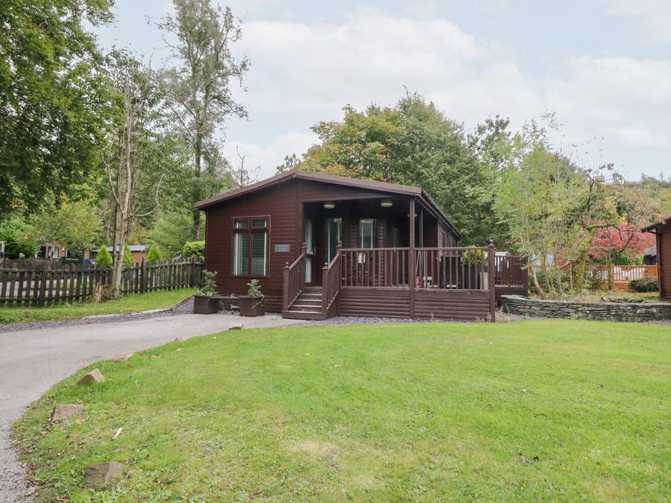 A cabin with a wooden deck and garden at Costapacket Windermere