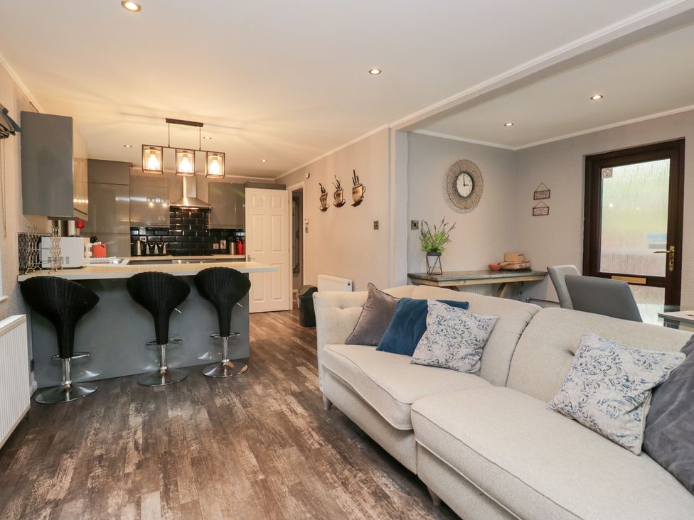 A living room with a kitchen counter and seating at Costapacket in Windermere