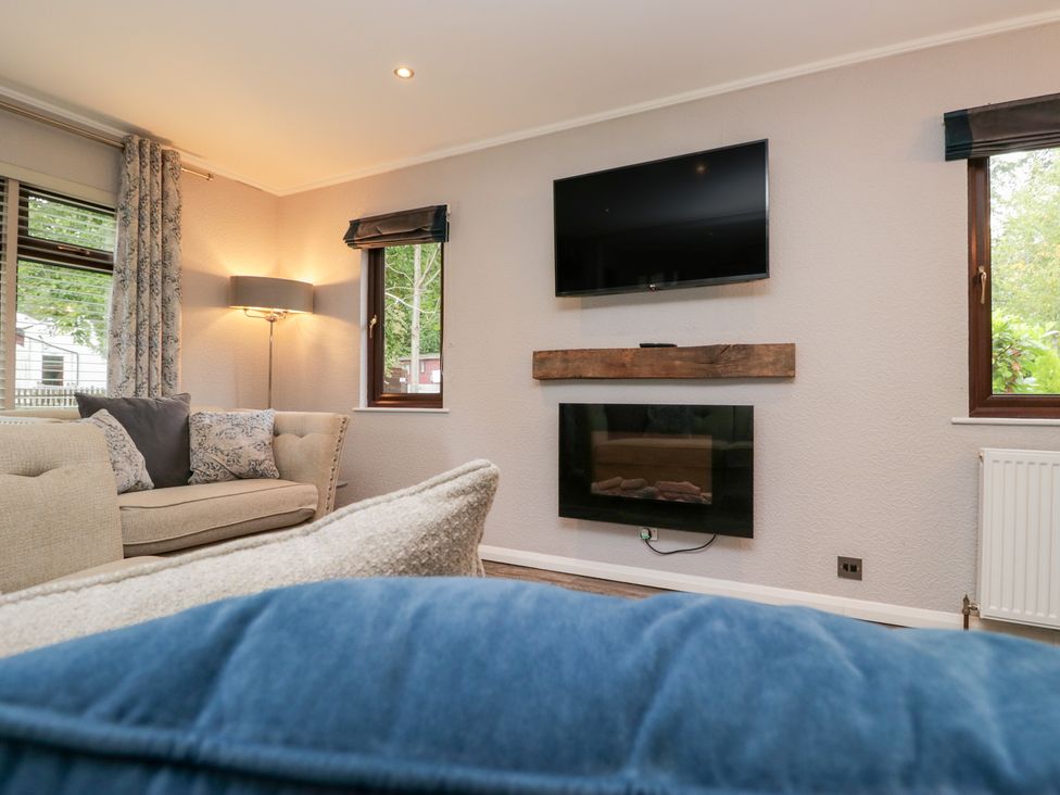 A living room with a sofa and television at Costapacket in Windermere