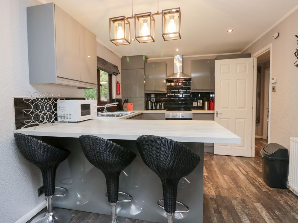 A kitchen with stools and appliances at Costapacket in Windermere
