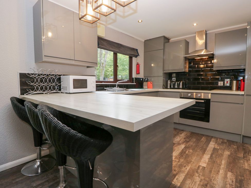 A kitchen with an island and bar stools at Costapacket in Windermere