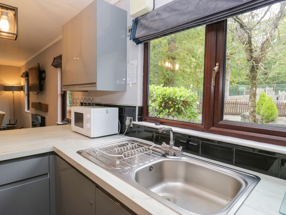 A kitchen with a sink and microwave at Costapacket in Windermere