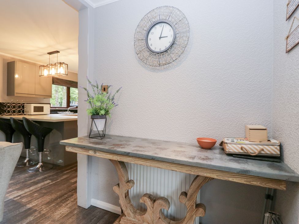 A kitchen area with a table and clock at Costapacket in Windermere