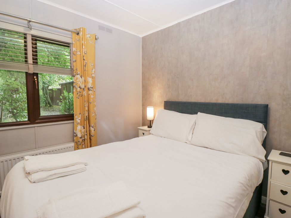 A bedroom with a bed and lamp at Costapacket in Windermere