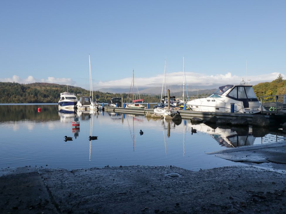 A dock with boats and ducks on water at Costapacket in Windermere