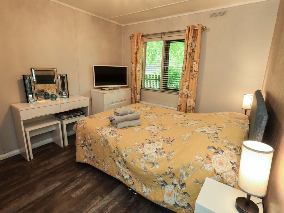 A bedroom with a bed and television at Costapacket, Grasmere 12, White Cross Bay near Windermere
