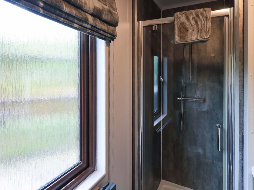 A bathroom with a shower and window at Costapacket, Grasmere 12, White Cross Bay near Windermere