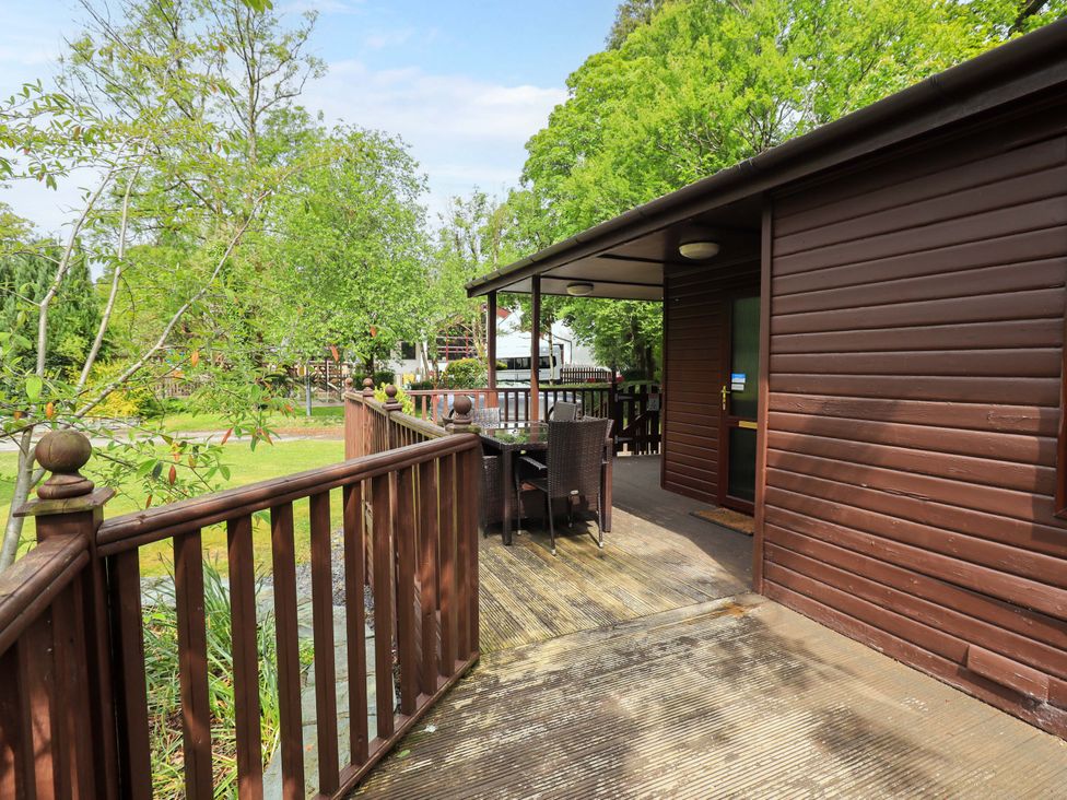An outdoor deck area with a table and chairs at Costapacket in Grasmere 12, White Cross Bay near Windermere