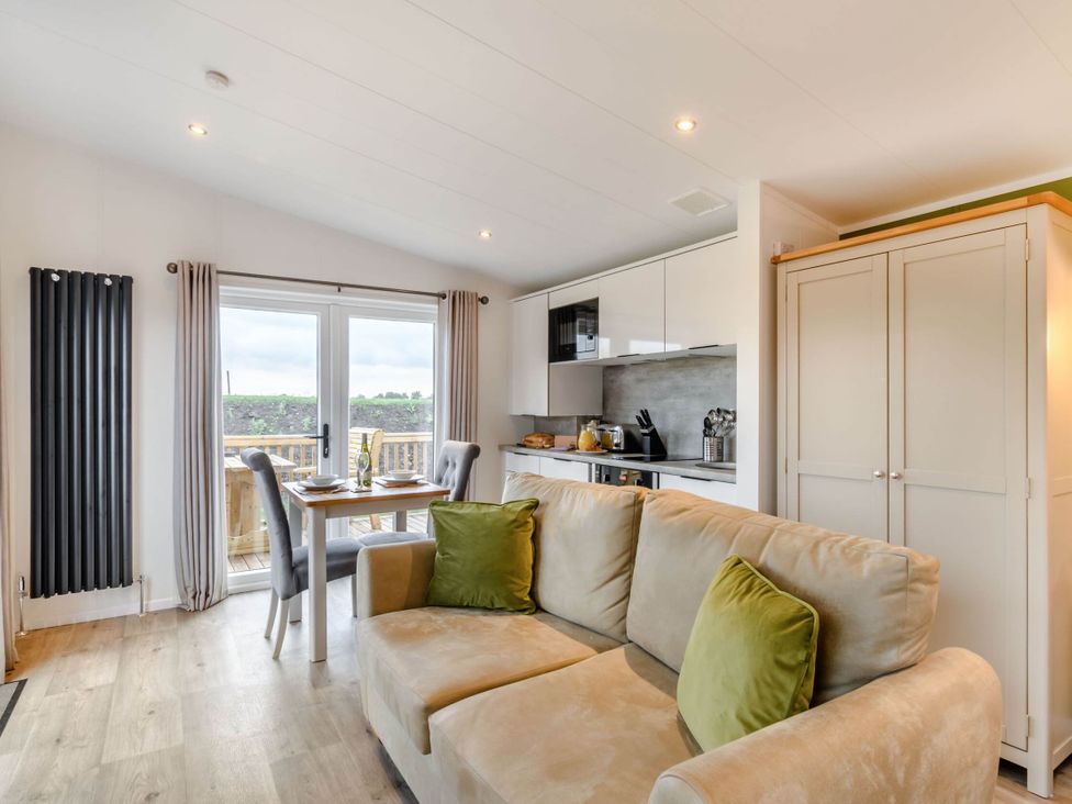 A living room with a sofa and dining area at Pear Tree in Thirsk