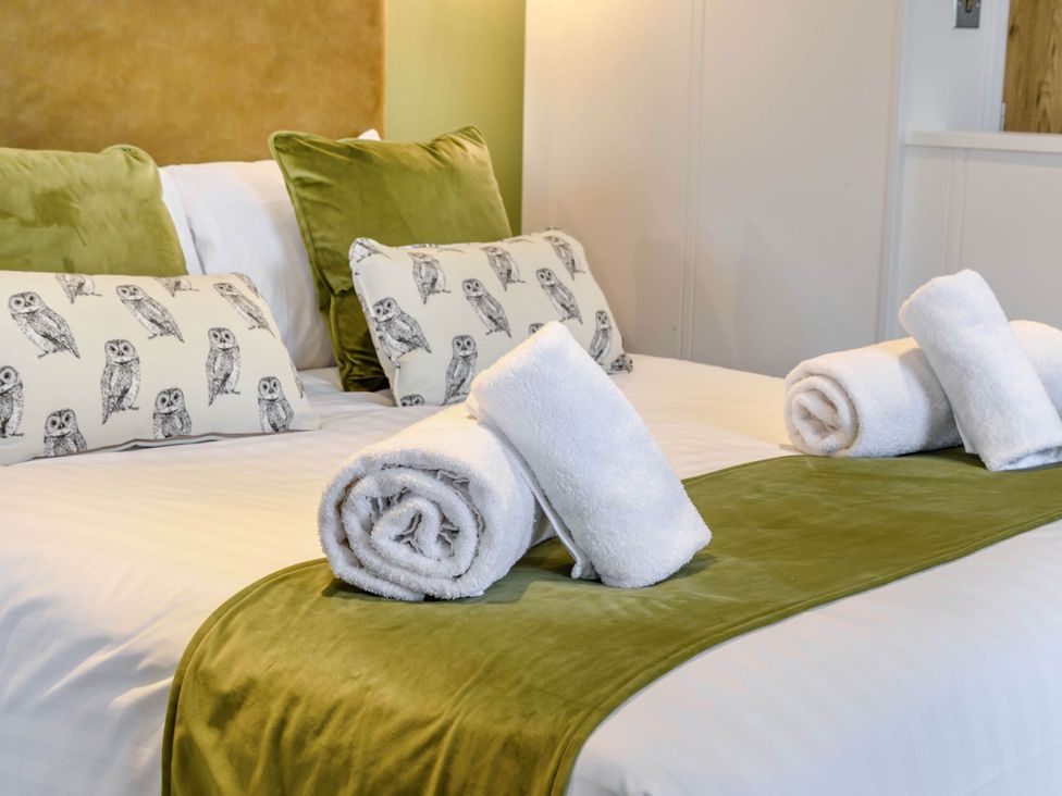 A bedroom with a bed and decorative pillows at Pear Tree in Thirsk