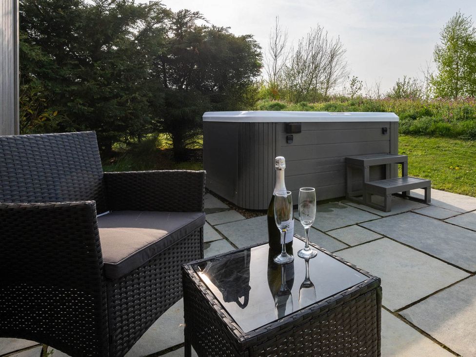An outdoor area with a hot tub and seating at Stokesley in Great Ayton