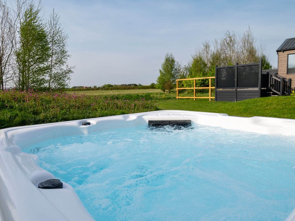 A hot tub surrounded by grass and trees at Stokesley in Great Ayton