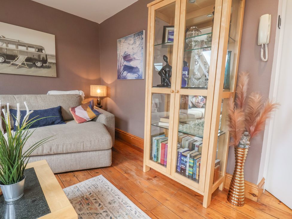A living room with a sofa and bookshelf at The Studio on the Crescent in Whitby