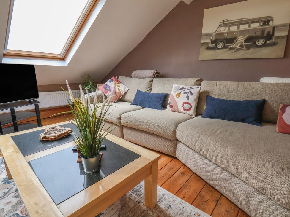 A living room with a sofa and television at The Studio on the Crescent in Whitby