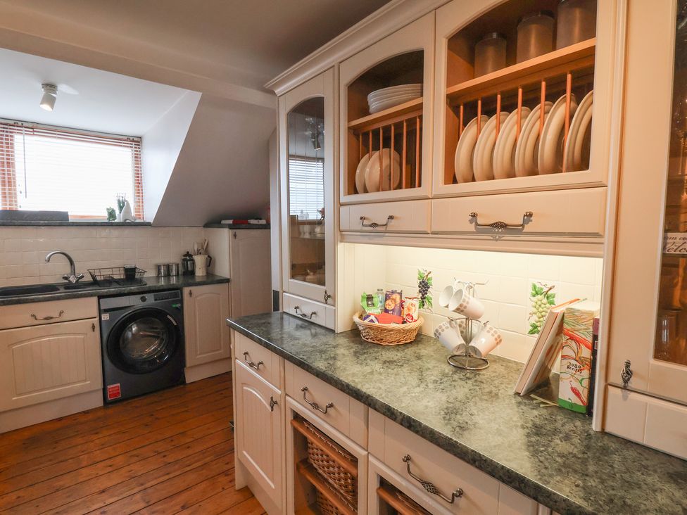 A kitchen with cabinets and a washing machine at The Studio on the Crescent in Whitby